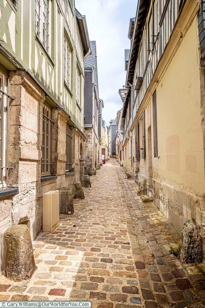 A narrowed cobbled lane lined with half-timbered buildings in the heart of historic rouen, normandy