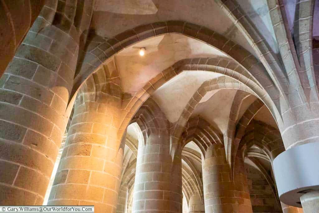 The colossal stone columns of the Great Pillared Crypt of Mont-Saint-Michel Abbey.