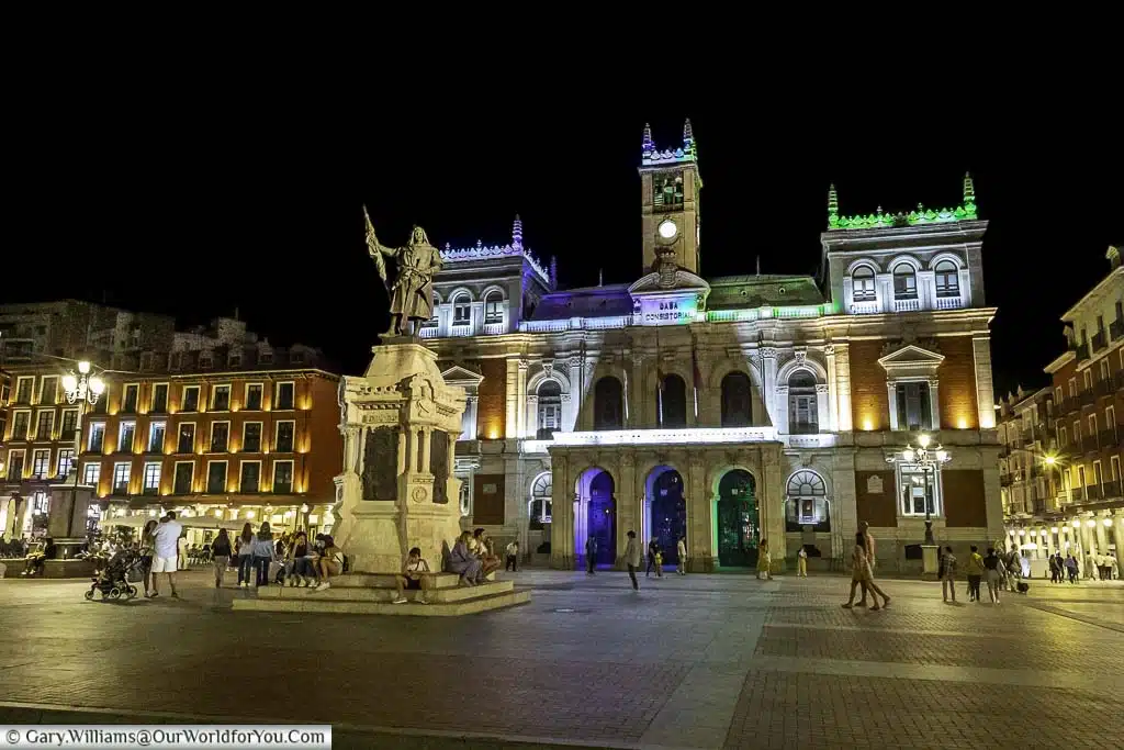 a statue of the founder of the valladolid, pedro ansúrez, in the centre of plaza mayor in front of the town hall at night