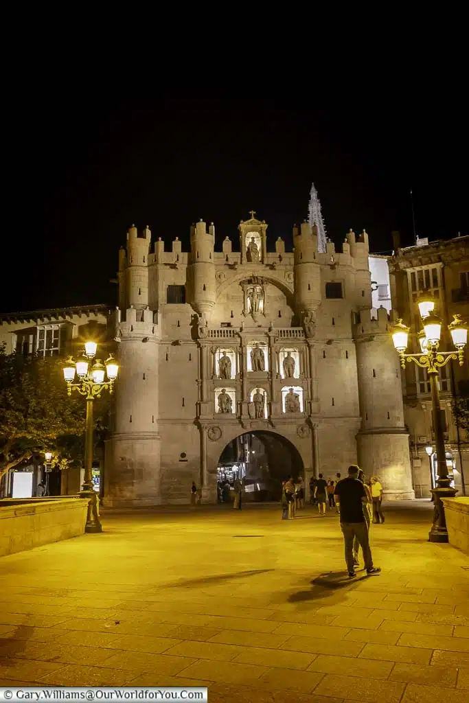 A shot late in the evening of the ornate medieval arco de santa maría leading into the cathedral square in Burgos, Spain