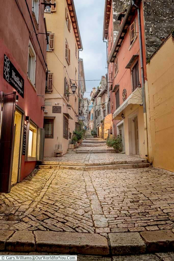 a quaint cobbled back street heading up hell at dusk in rovinj, croatia