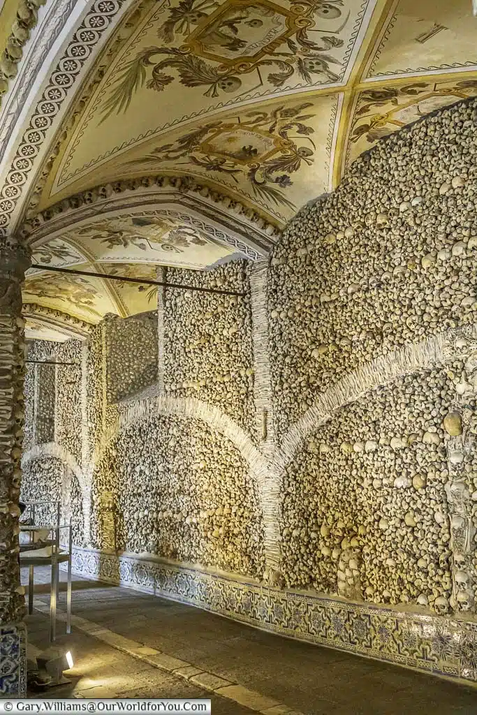Inside the vaulted Chapel of Bones with a beautifully decorated ceiling and walls lined with a mixture of skulls & bones.