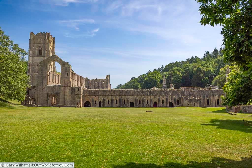 A majestic view of the ruins of Fountains Abbey in Yorkshire, one of England’s largest and best-preserved Cistercian monasteries, set in a tranquil green valley. Surrounded by lush woodland, this UNESCO World Heritage Site offers a breathtaking glimpse into medieval monastic life and is a must-visit for history and nature lovers.