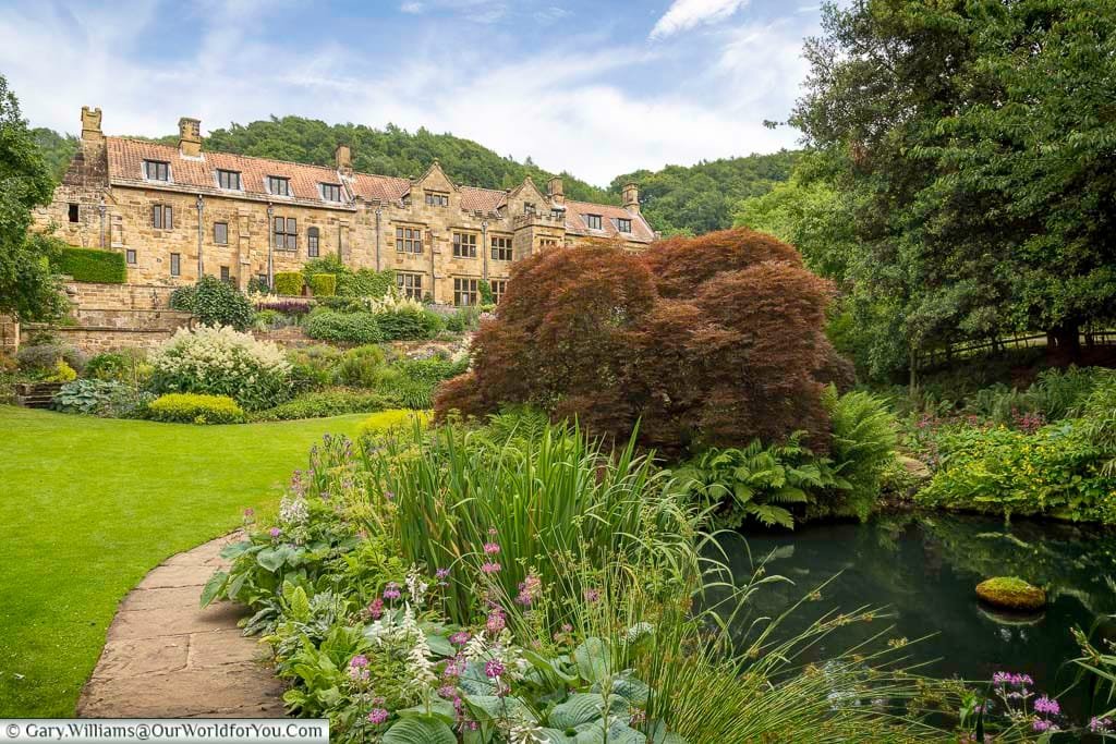 A beautifully landscaped garden with a reflective pond frames the historic Mount Grace Priory, a stunning medieval manor house nestled in the North York Moors. This peaceful heritage site offers a perfect blend of history and horticulture, making it a must-visit destination on any Yorkshire road trip.