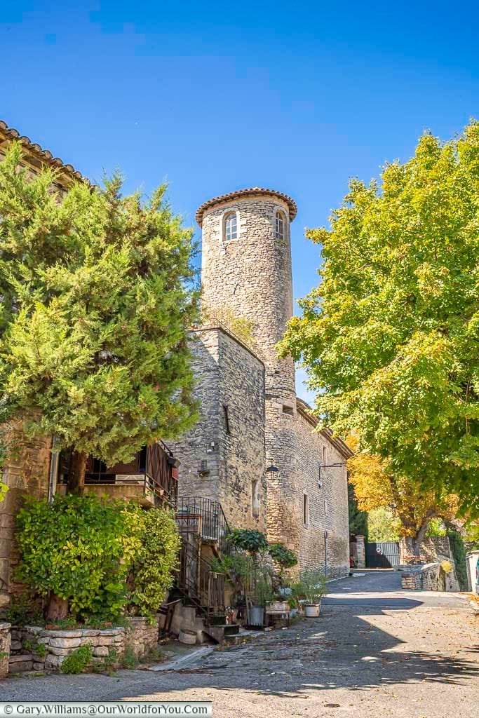 A picturesque view of the stone tower at Château de Goult in Provence, framed by lush greenery and traditional village charm. This hidden gem in southern France offers a perfect glimpse into the region’s rich medieval history and architectural beauty.