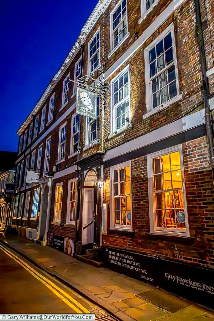 The Guy Fawkes Inn in York, a historic pub lit warmly at night where the infamous figure was born. This atmospheric location offers visitors a unique experience of York’s history and charm.