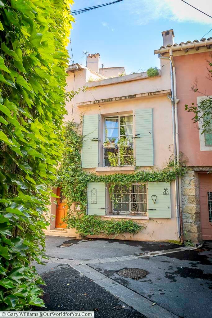 Charming pastel-coloured house with mint-green shutters nestled in the narrow historic lanes of L’Isle-sur-la-Sorgue, Provence. This picturesque corner captures the timeless beauty of French village life and is a must-see stop on a Provençal road trip.