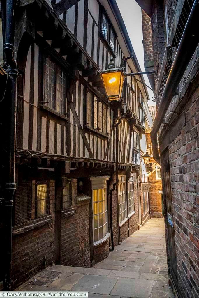Lady Peckett’s Yard in York showcases narrow medieval passageways with timber-framed buildings and glowing lanterns. This hidden gem highlights York’s enchanting history and atmospheric old streets.
