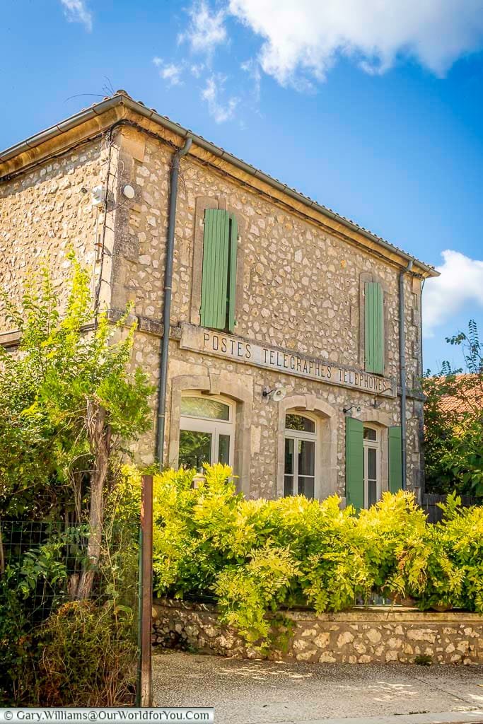 Charming stone building in Eygalières, Provence, featuring green shutters and vintage signage for "Postes Télégraphes Téléphones." This beautifully preserved post office captures the timeless character of one of the best villages in southern France.