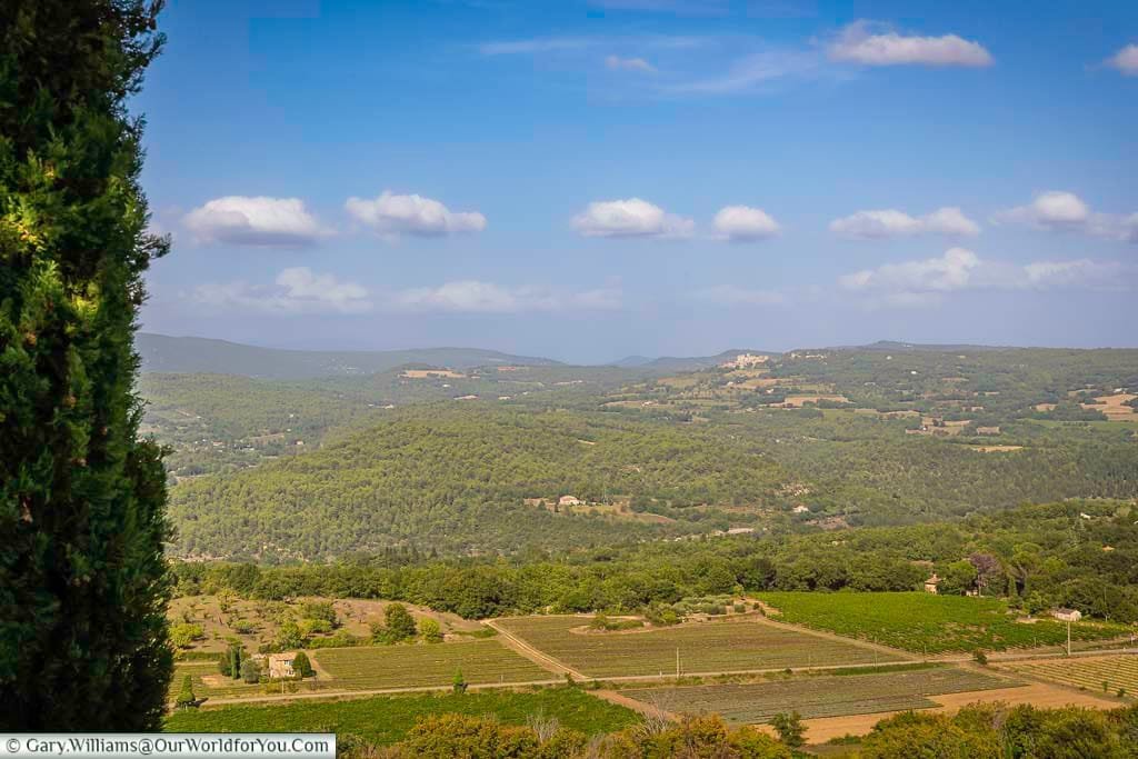Breathtaking panoramic view from Rocher de Bellevue in Provence, showcasing rolling hills, vineyards, and lush countryside under a blue summer sky. This scenic lookout captures the natural beauty and charm of rural southern France, ideal for road trip and travel inspiration.