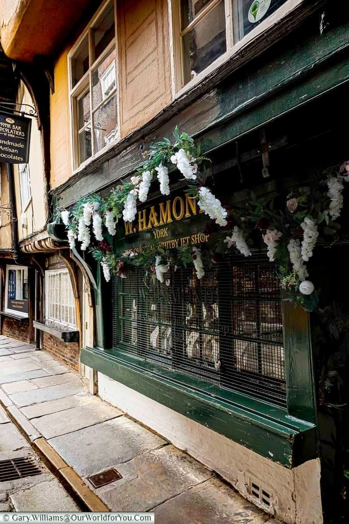 The W. Hamond shop in York, known as the original Whitby Jet jeweller, is nestled in the historic Shambles. Its traditional storefront and floral displays make it a must-visit heritage shopping spot in the city.