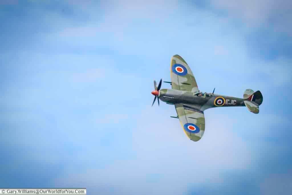A classic World War II Spitfire soars through the sky during a heritage flypast at the Kent County Show, showcasing British aviation history. This iconic RAF aircraft is a powerful symbol of wartime bravery and a highlight for visitors at UK summer events.