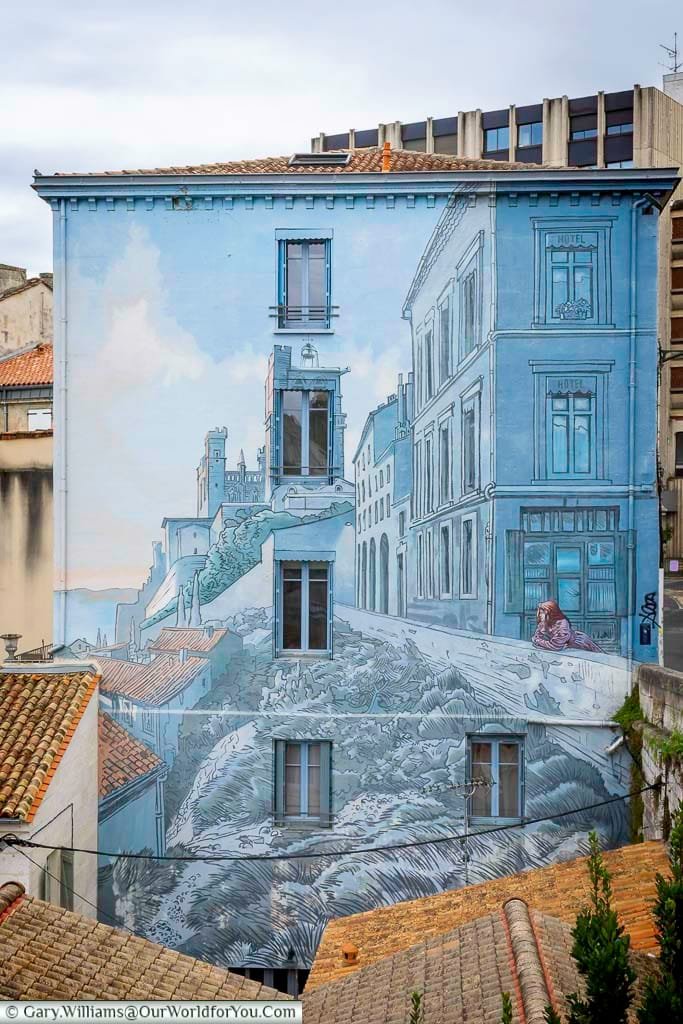 Striking building mural in Angoulême, France, depicting a scenic blend of urban architecture and historic landscapes. Known for its comic art, Angoulême surprises visitors with street murals that celebrate French heritage and creativity.
