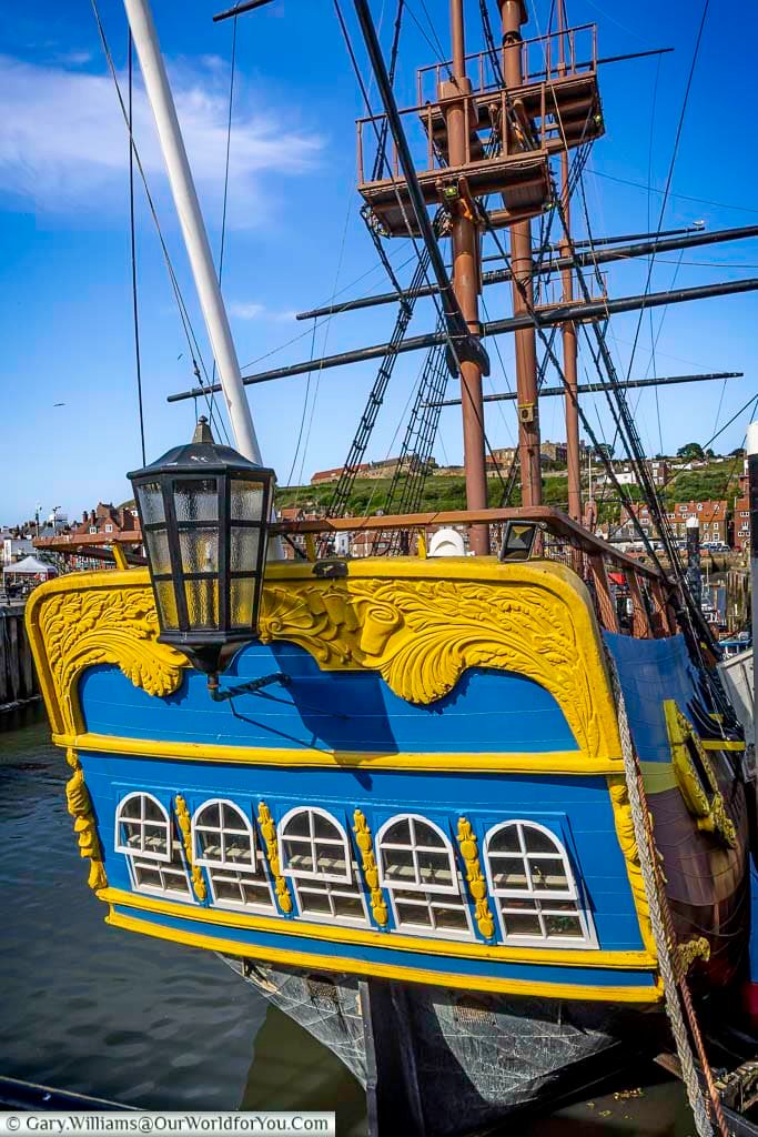 A colourful close-up of the stern of the HMS Endeavour replica docked in Whitby Harbour, showcasing its vivid blue and yellow detailing. This tribute to Captain James Cook’s famous ship celebrates Whitby’s maritime legacy.