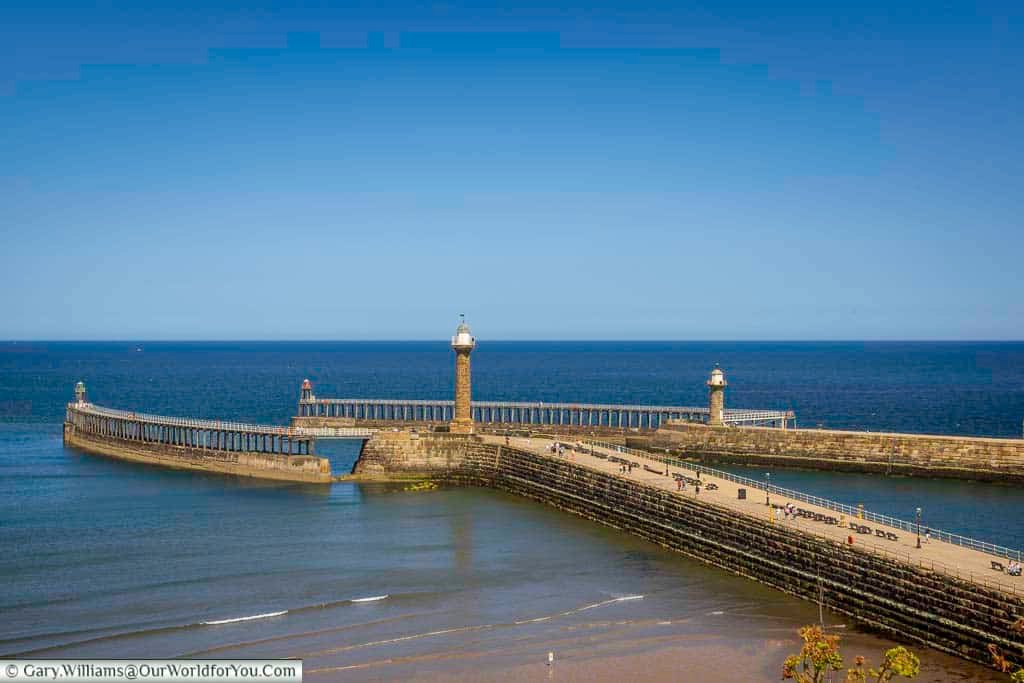 The twin piers of Whitby stretch out into the North Sea, framing the mouth of the River Esk and guiding vessels home. A defining view of the Yorkshire coast, perfect for strolls and sea views.