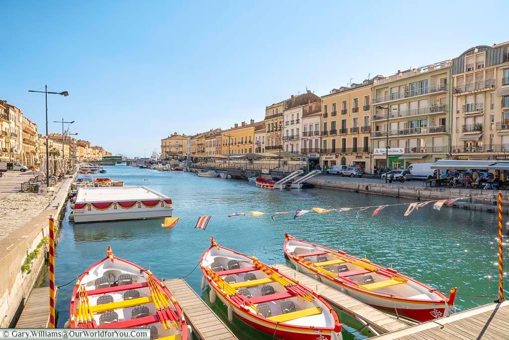 Brightly coloured jousting boats line the edge of Le Cadre Royal in Sète, a central canal steeped in tradition and framed by elegant buildings. This lively waterfront is the heart of the town’s water jousting festivals and a must-visit in southern France.