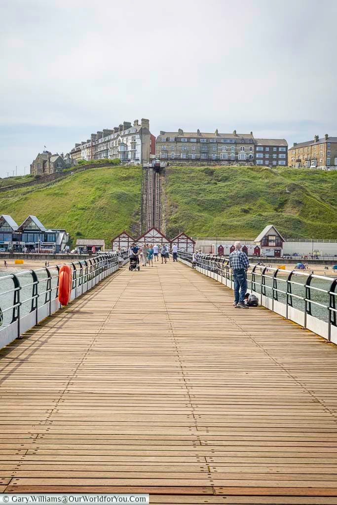 A view from the end of Saltburn Pier reveals the charming Victorian town above the cliffs, with the famous Saltburn Cliff Tramway tracks leading down to the seafront. This unique perspective captures the seamless blend of heritage and scenic beauty that defines Saltburn-by-the-Sea.