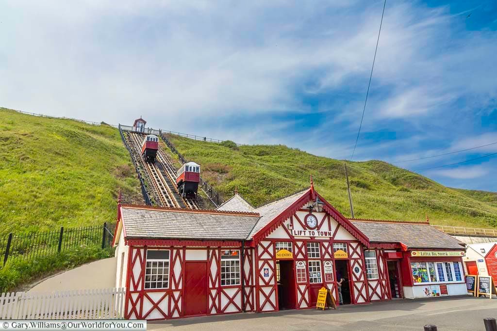 The iconic Saltburn Cliff Tramway, one of the world’s oldest water-powered funiculars, ascends the steep grassy hillside behind its striking red-and-white Victorian station. A beloved landmark, it links the town centre with Saltburn’s seafront and pier below.