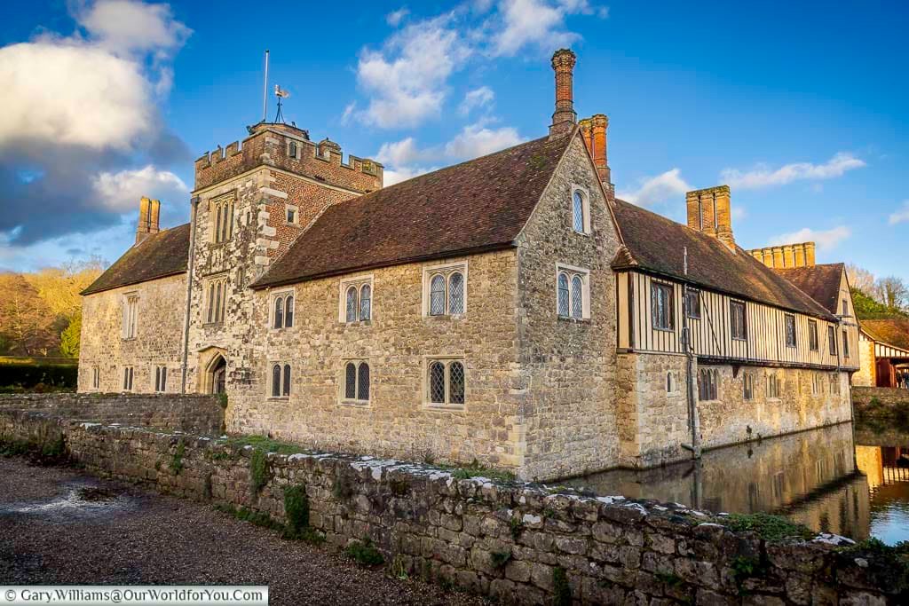 A classic exterior view of Ightham Mote in Kent, with its stone walls, Tudor features, and surrounding moat reflecting the historic manor. This beautifully preserved National Trust property is one of the finest medieval houses in England and a must-see attraction in Kent.