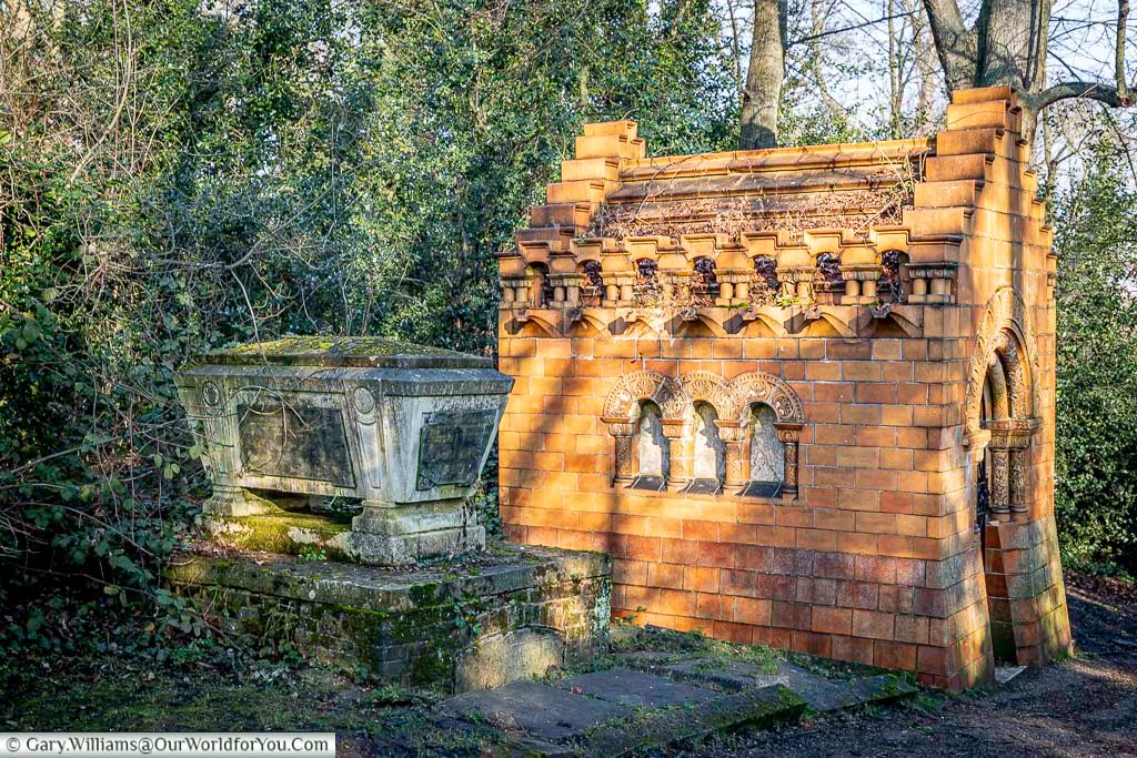 Brick-built Stearns mausoleum with decorative Romanesque arches and patterned stonework in Nunhead Cemetery, south London. The richly coloured structure showcases Victorian funerary architecture set within a peaceful woodland landscape.