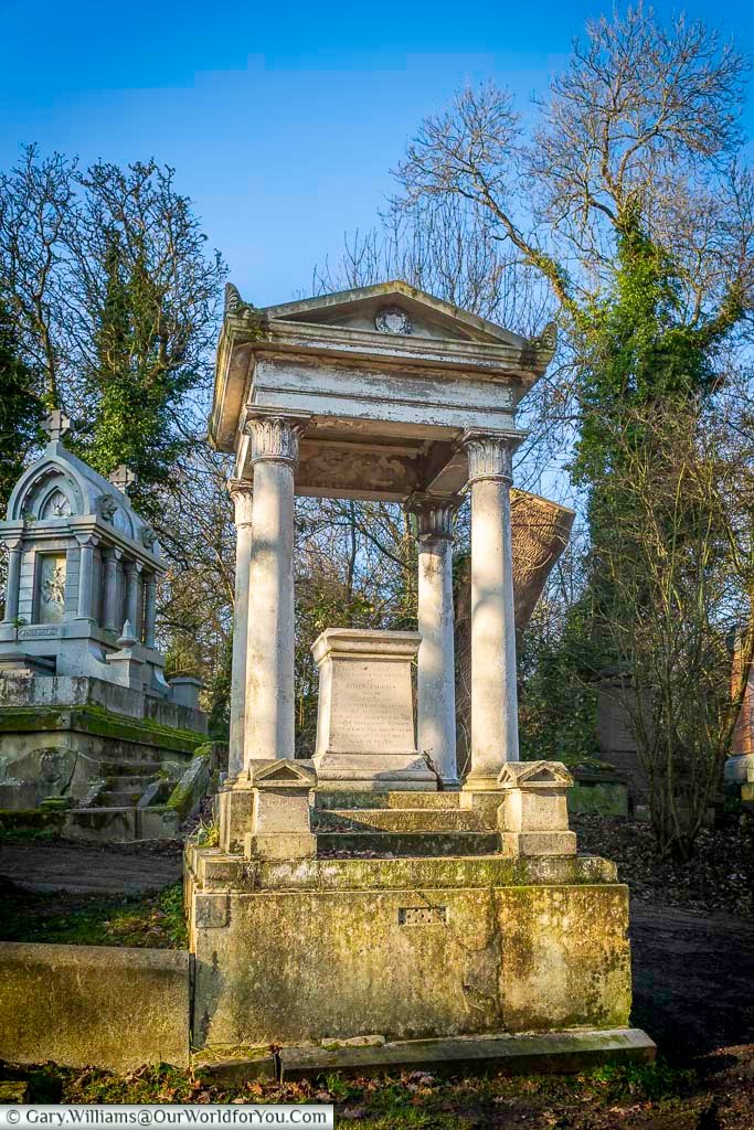 Neoclassical tomb of Vincent Figgins with tall columns and a pedimented canopy in Nunhead Cemetery, London. This imposing monument reflects 19th-century memorial design and the prominence of Victorian typography pioneers.