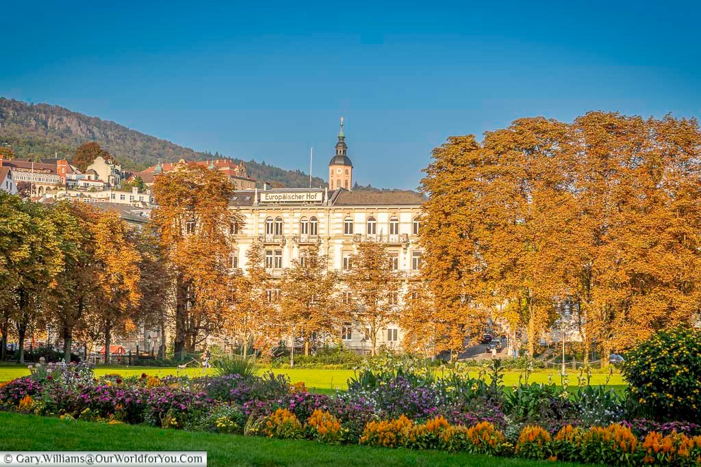 View across landscaped gardens in Baden-Baden towards elegant spa buildings and classical architecture. These green spaces form part of the town’s relaxing atmosphere, ideal for strolling between thermal baths and historic landmarks.