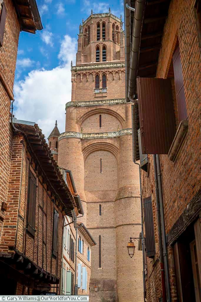 View of Albi Cathedral bell tower rising above narrow brick streets in the Castelviel quarter. This striking perspective emphasises the scale and dominance of Albi’s UNESCO-listed cathedral within the old town.