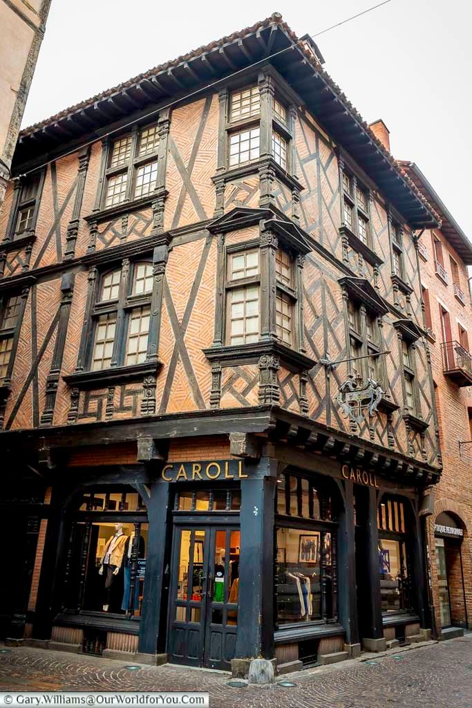 Half-timbered Enjalbert House in Albi, showcasing intricate wooden beams and red brick infill on a medieval street corner. This beautifully preserved building reflects the rich architectural history of Albi’s old town.