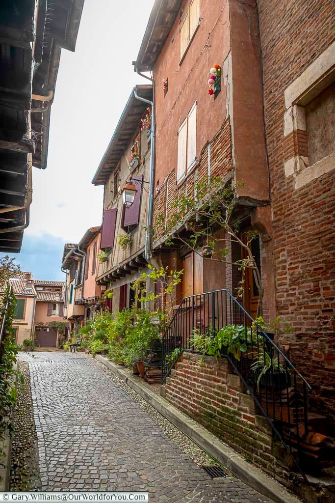 Narrow cobbled alley in Albi framed by red-brick buildings and shuttered windows. This atmospheric street offers a glimpse into Albi’s preserved medieval street layout and historic urban life.