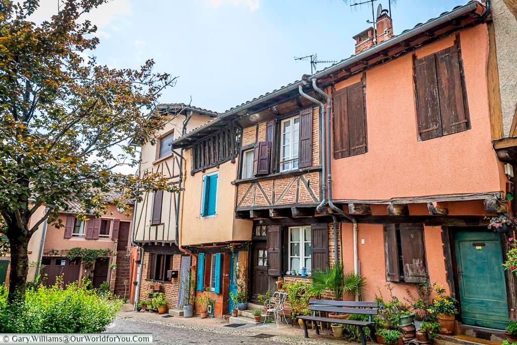 Picturesque half-timbered houses in Albi with wooden beams, terracotta tones, and potted plants along a peaceful square. This charming setting reflects the authentic character of Albi’s old town and Occitan architecture.