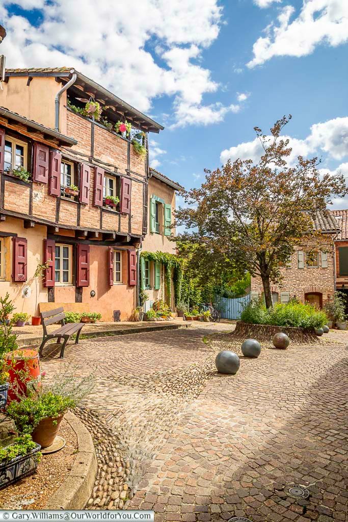 Historic square in Albi featuring cobbled paving, traditional brick houses, and leafy trees. This inviting public space reveals the relaxed pace and timeless charm of Albi’s medieval neighbourhoods.