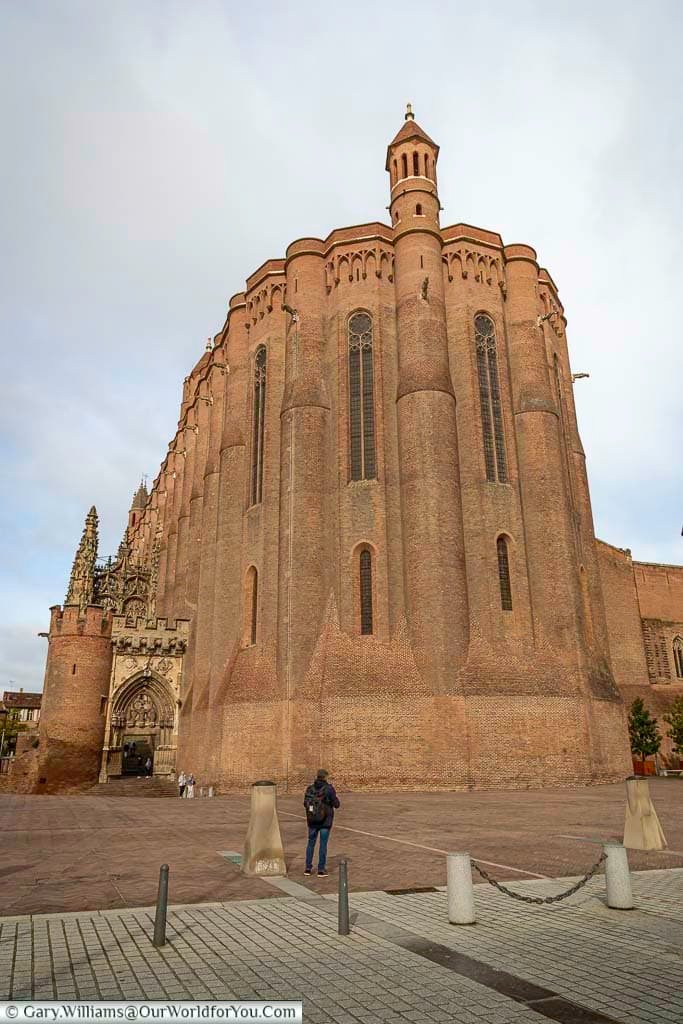 Exterior view of Sainte-Cécile Cathedral in Albi, showing its immense fortified brick walls dominating the city square. This UNESCO World Heritage landmark is the largest brick cathedral in the world and a must-see highlight of Albi sightseeing.