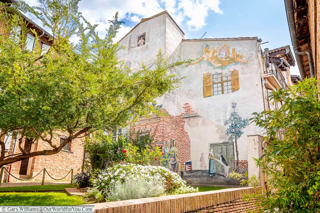 Colourful mural and garden courtyard in Albi, blending street art with historic brick buildings. This creative scene showcases Albi’s artistic spirit and lesser-known hidden gems beyond the main tourist routes