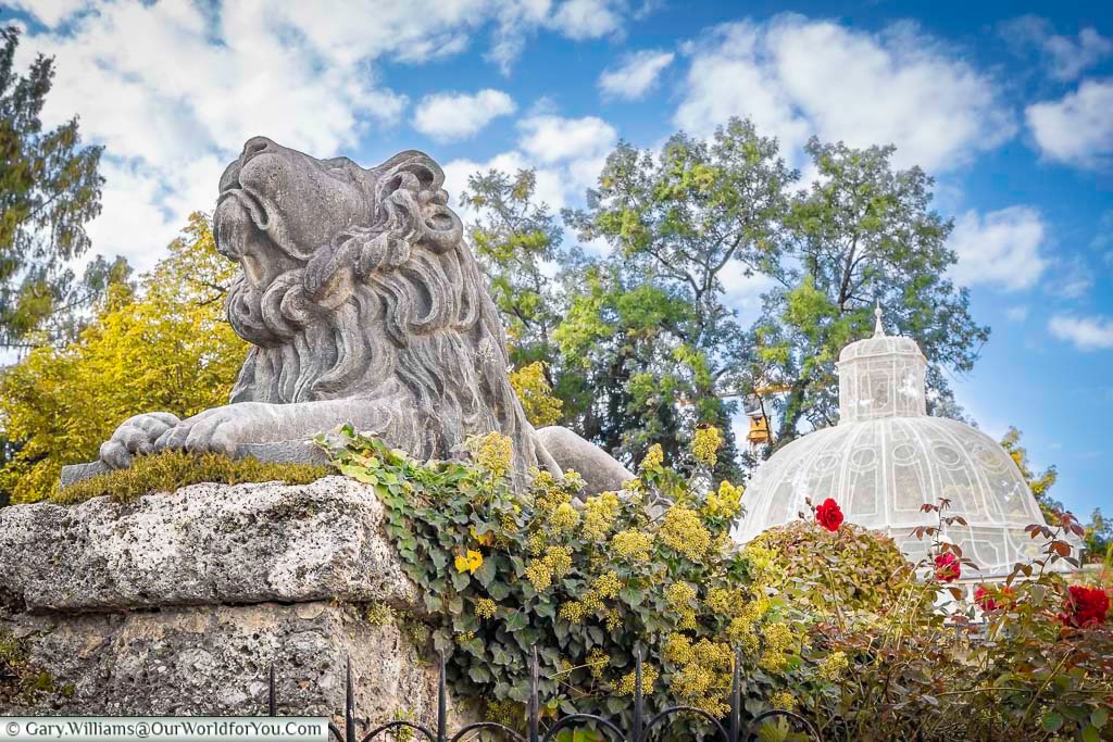 A stone lion sculpture overlooks the Mirabell Palace Gardens, framed by manicured greenery and seasonal flowers. This elegant garden is one of Salzburg’s most romantic and photographed attractions.