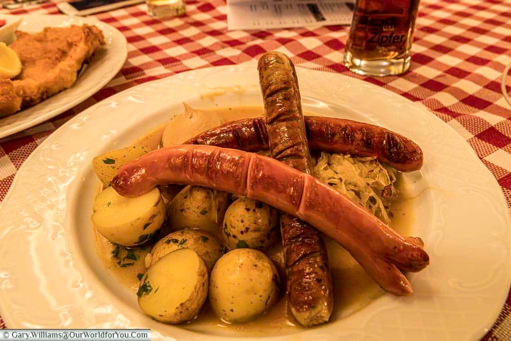 A traditional Austrian sausage dish served with potatoes, sauerkraut, and mustard in a Salzburg brauhaus. This hearty local meal is a classic example of Salzburg cuisine and an essential food experience when visiting Austria.