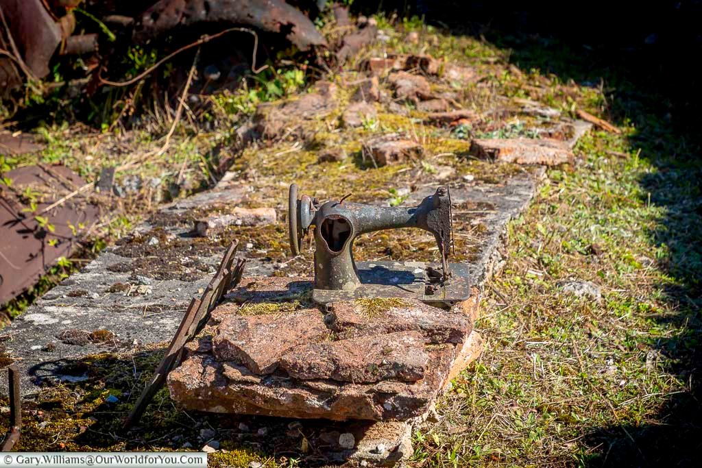 An abandoned sewing machine sits on a stone base among the ruins of Oradour-sur-Glane in France. This haunting wartime relic is a powerful reminder of the village’s tragic destruction during World War II.