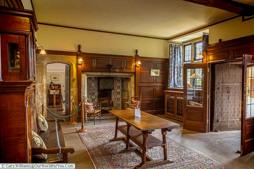 The historic entrance hall at Mount Grace House features wooden panelling, a large fireplace, and period furnishings. This beautifully preserved Tudor manor house in North Yorkshire offers visitors a glimpse into life in a National Trust property.