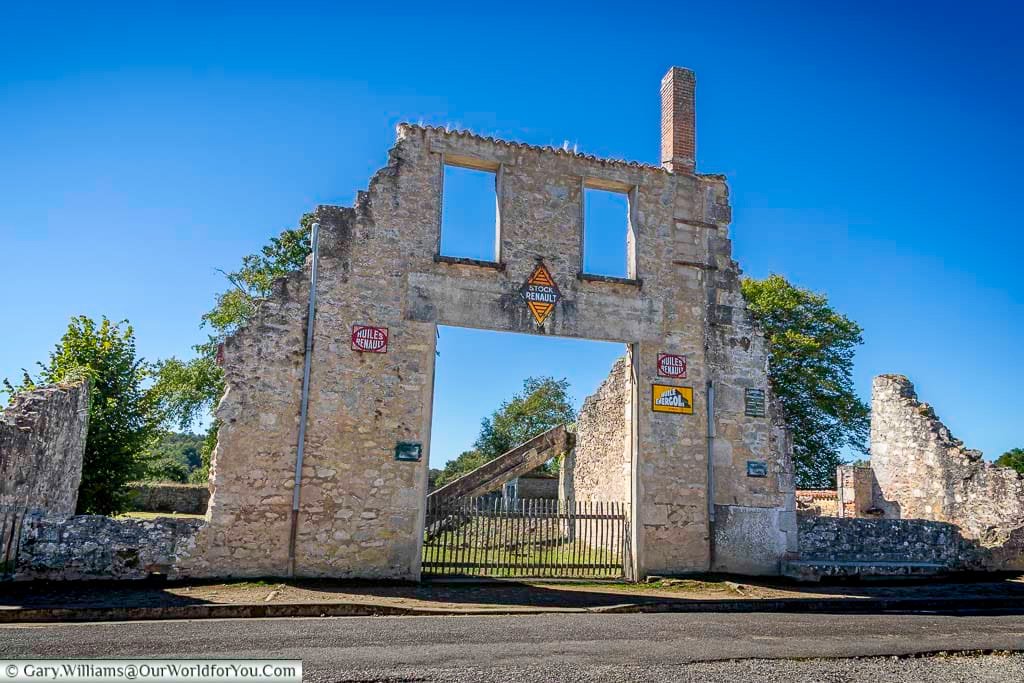A ruined garage building in Oradour-sur-Glane, showing the crumbling stone walls and empty doorways of the destroyed village. The scene captures the lasting impact of the 1944 massacre and why Oradour-sur-Glane remains one of France’s most important memorial sites.