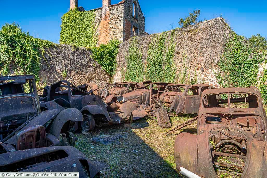 A collection of burnt-out cars preserved in Oradour-sur-Glane, left rusting where they were abandoned during the 1944 massacre. The vehicles and surrounding ruins create one of the most striking and emotional sights in this historic memorial village in France.
