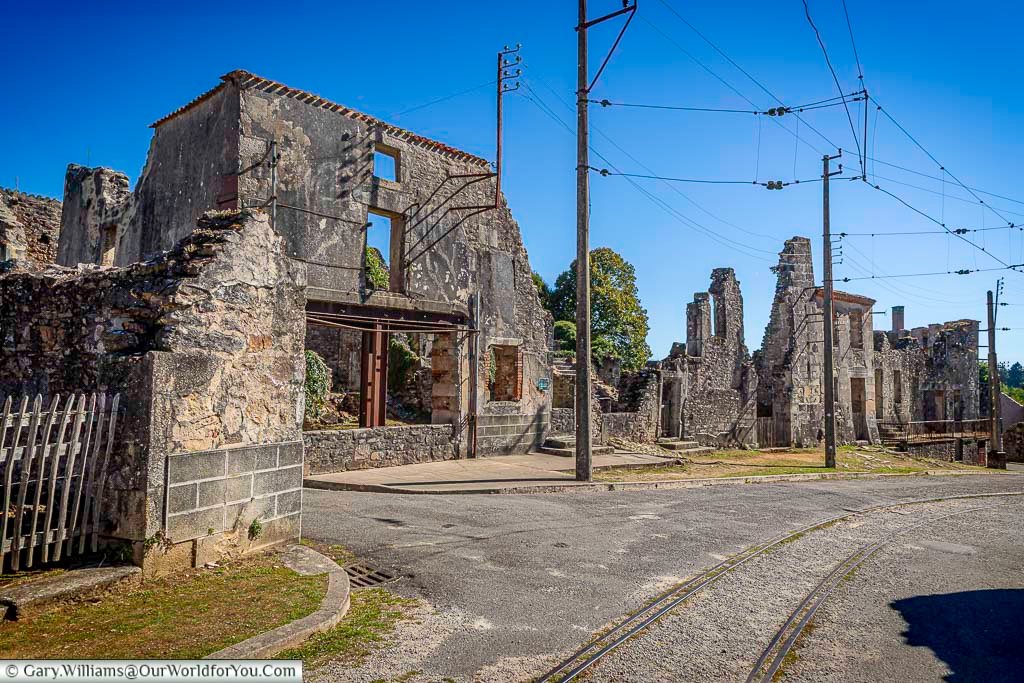 A wide street lined with ruined buildings shows the main route through Oradour-sur-Glane, France. Preserved as a World War II memorial, the village remains frozen in time after its destruction in June 1944.