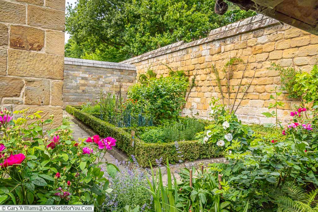 A walled garden filled with flowers and greenery sits inside one of the restored monk’s cells at Mount Grace Priory in Yorkshire. The peaceful layout reflects how Carthusian monks lived in solitude within this unique monastery.