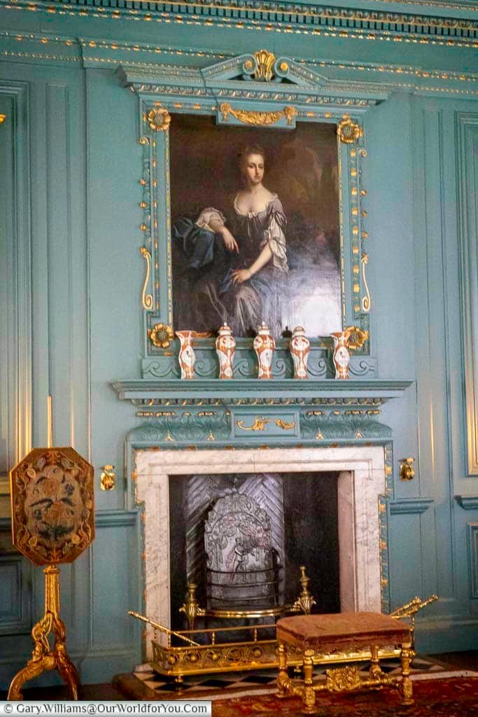 An elegant fireplace framed by decorative panelling and a portrait forms the focal point of the Drawing Room at the Treasurer’s House in York. The refined interior design reflects the sophistication of this renowned National Trust property in Yorkshire.