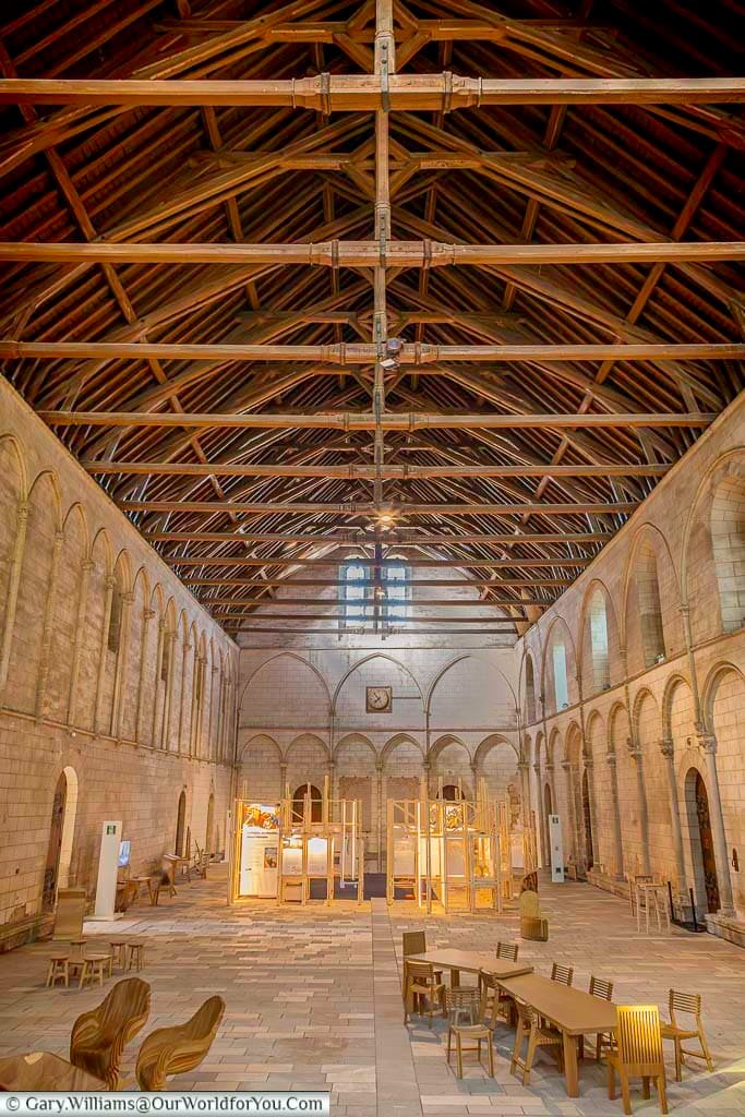 The vast medieval Great Hall of the Palace of Poitiers showcases an impressive timber roof structure and elegant stone arcades along its walls. This historic hall, known as La Salle des Pas Perdus, is one of the largest surviving medieval civic interiors in Europe and a highlight when visiting Poitiers, France.