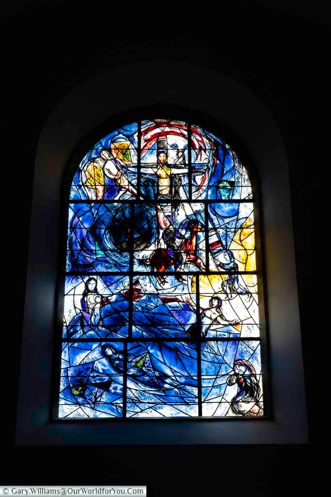 The memorial east window at All Saints’ Church, Tudeley, designed by Marc Chagall, depicts a powerful biblical scene in vivid blues and reds. This iconic artwork is a central highlight for visitors exploring historic churches in Kent.