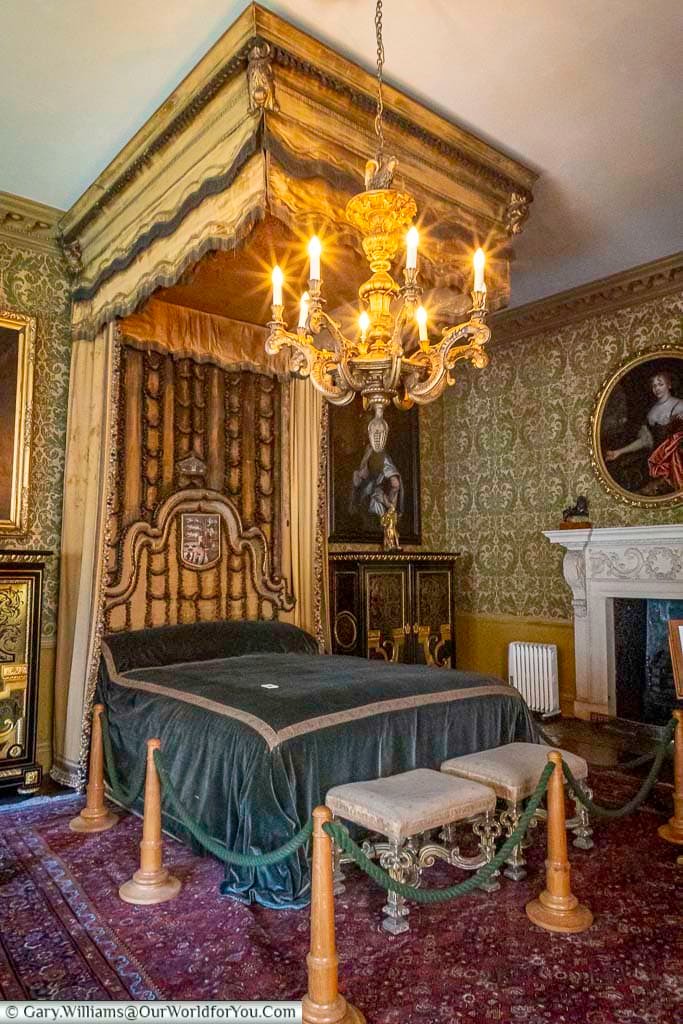 A luxurious four-poster bed with ornate canopy and chandelier dominates the Queen’s Room at the Treasurer’s House in York. This beautifully preserved historic bedroom offers a glimpse into aristocratic life in Georgian York.