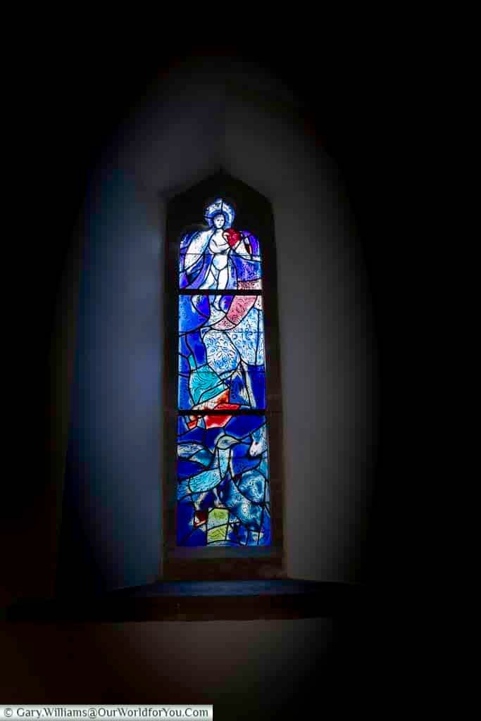 A vivid Marc Chagall stained glass window in All Saints’ Church, Tudeley, features an angel with symbolic imagery including a harp, bird, and donkey in rich blue tones. These unique artworks make the church a must-visit hidden gem in Kent for art and culture enthusiasts.
