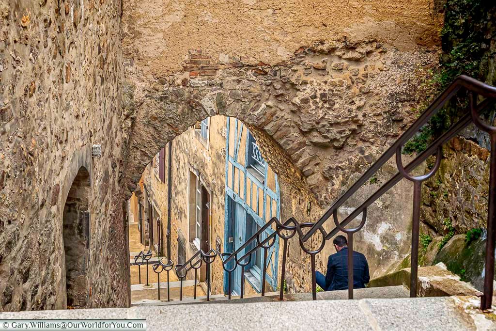 Stone steps descend beneath an ancient archway at Escalier de la Grande Poterne in Le Mans’ old town. This historic staircase offers a scenic route through the city’s medieval walls and architecture.