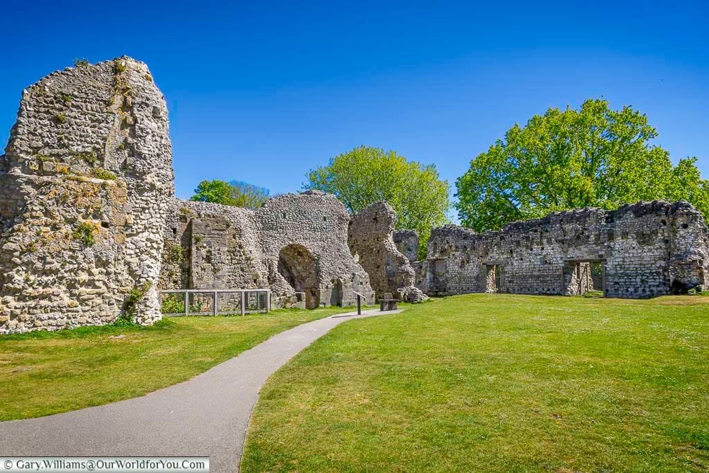 The ruins of Lewes Priory in East Sussex showcase the remains of one of England’s first Cluniac monasteries, surrounded by green lawns and historic stone walls beneath a bright blue sky. This peaceful medieval site is a must-see attraction in Lewes for visitors exploring English heritage, ancient ruins, and historic landmarks.