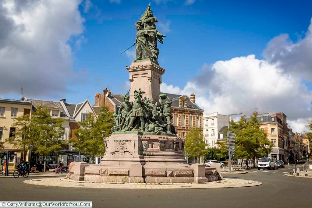 The impressive Monument de la Bataille de Saint-Quentin stands proudly in a city square surrounded by historic buildings and dramatic skies in northern France. This striking war memorial is an important landmark for visitors exploring Saint-Quentin’s history, heritage sites, and scenic walking tours.
