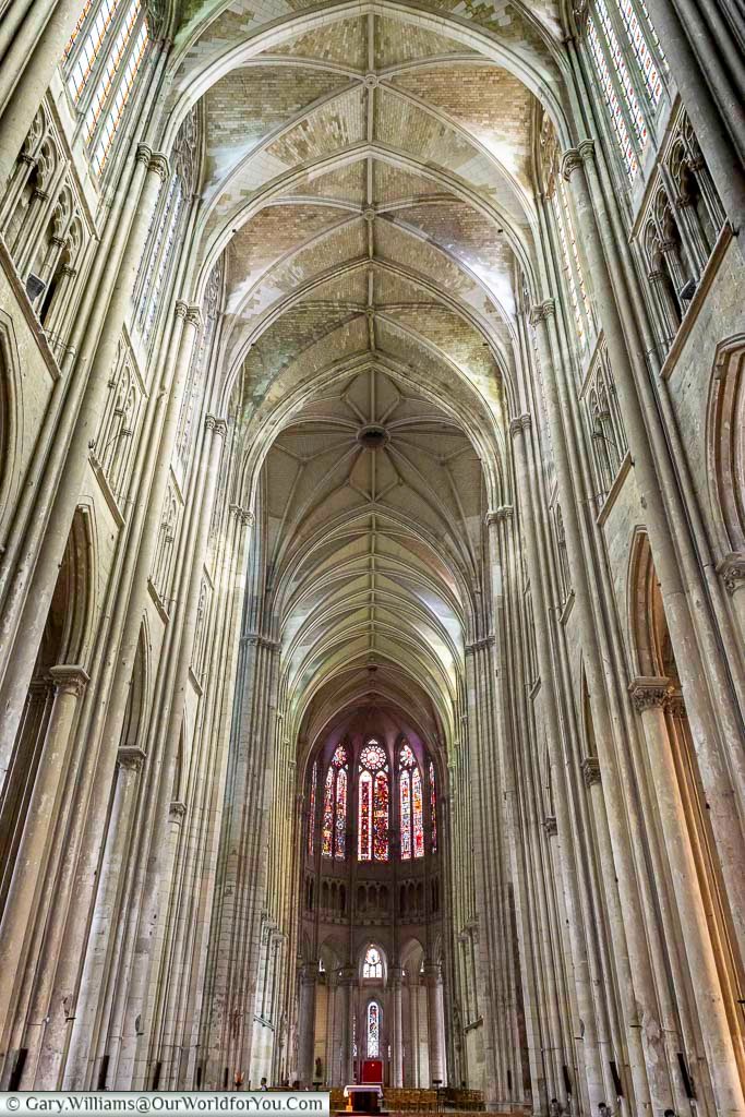 The vast nave of the Basilique de Saint-Quentin features towering stone columns, ribbed Gothic vaults, and glowing stained-glass windows that create an awe-inspiring atmosphere. This spectacular cathedral interior is a must-see destination for visitors interested in French Gothic architecture and historic churches.